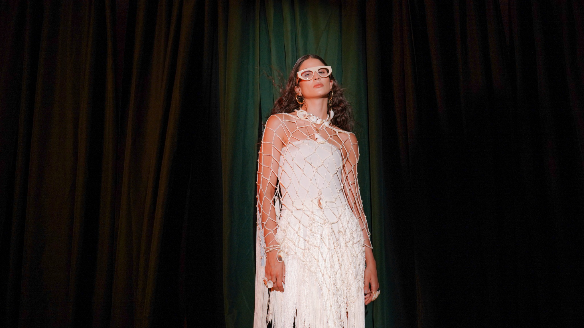 Editorial de moda de BLESS FRAME con modelo vestida de blanco frente a cortinas oscuras